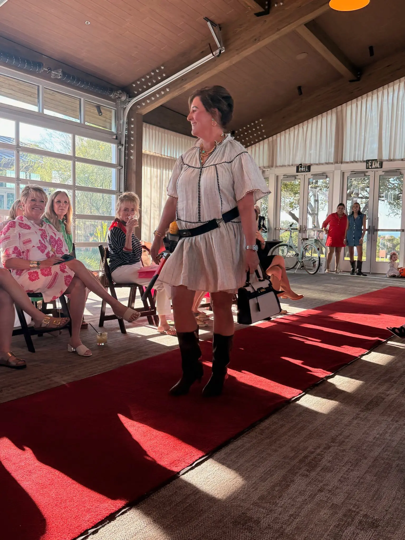 Woman walking red carpet at indoor fashion show