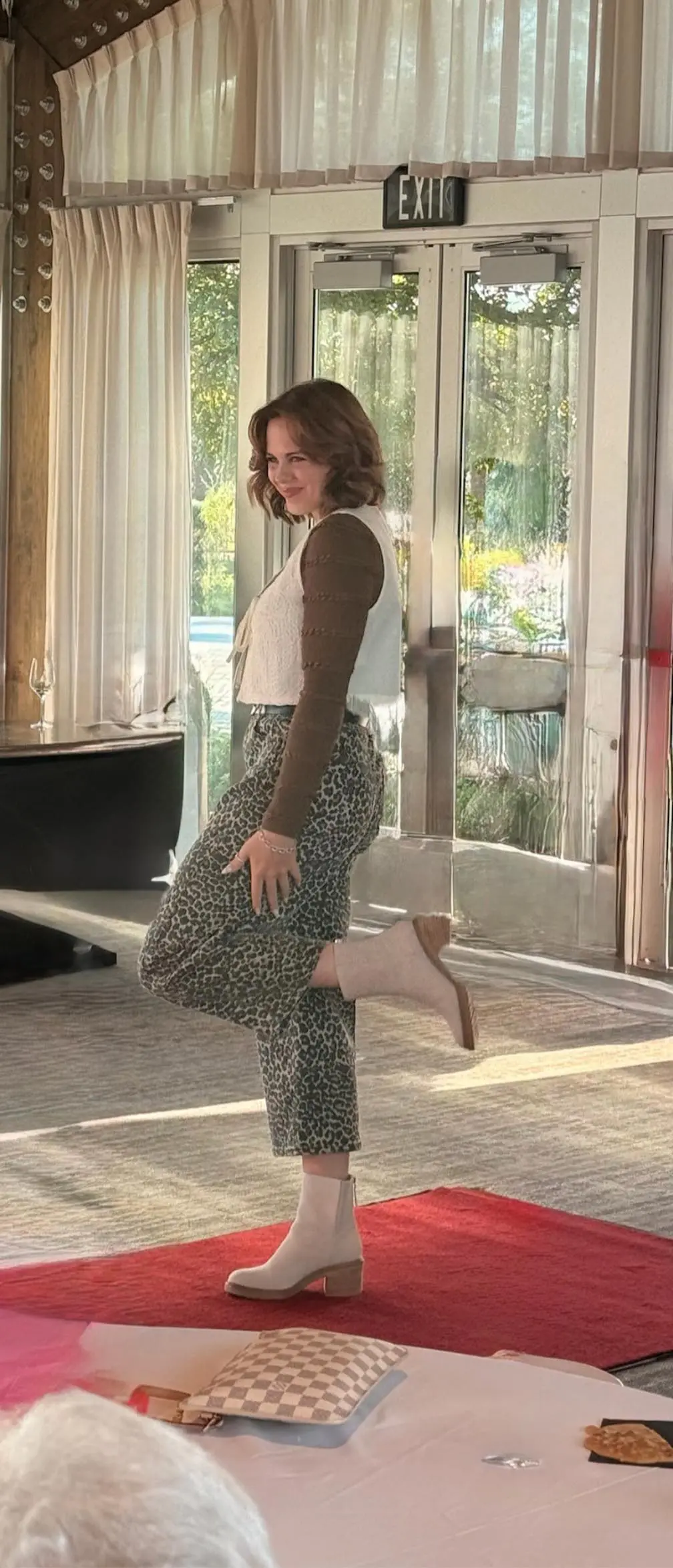Woman posing indoors in patterned pants and heels