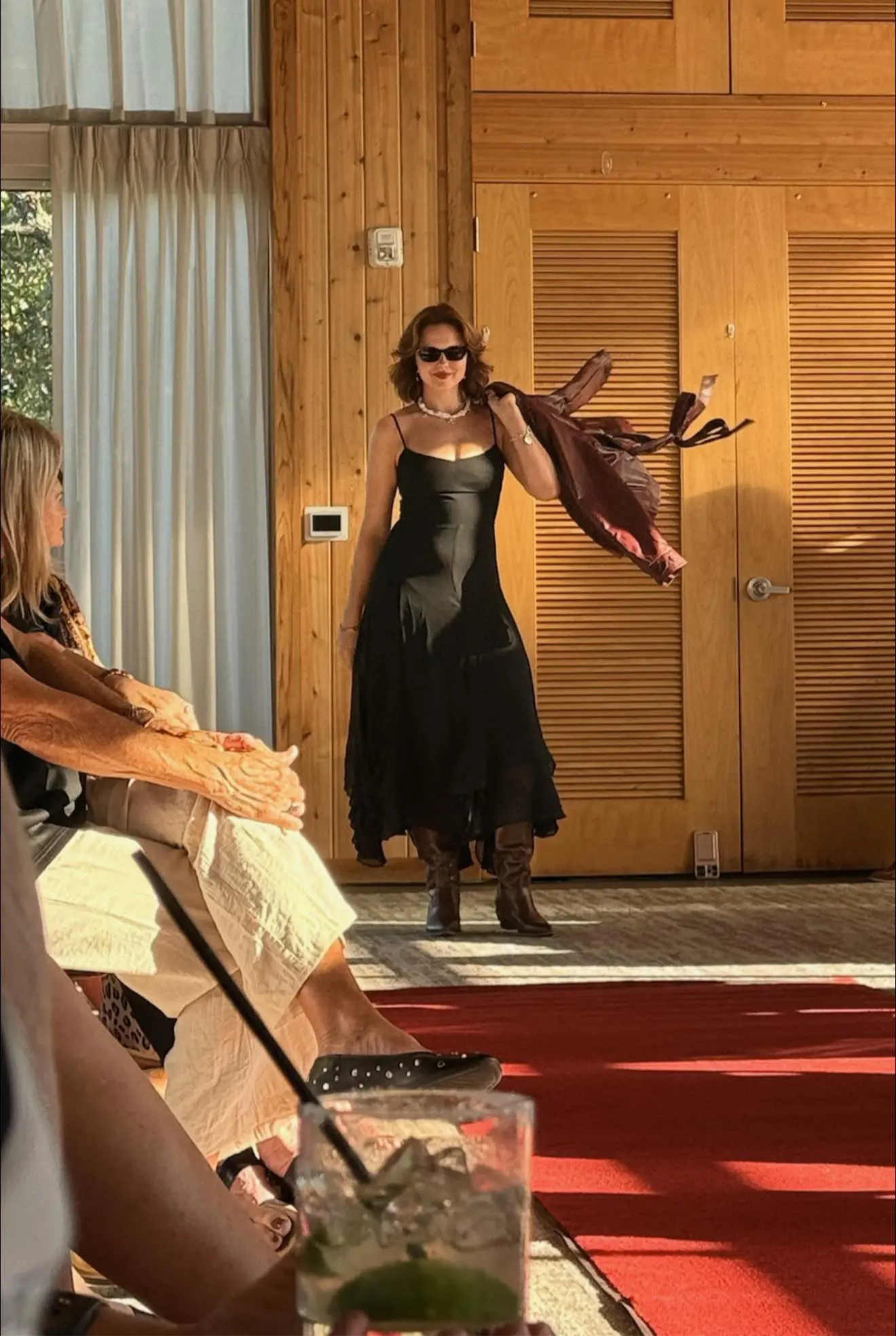 Woman in black dress and sunglasses walking
