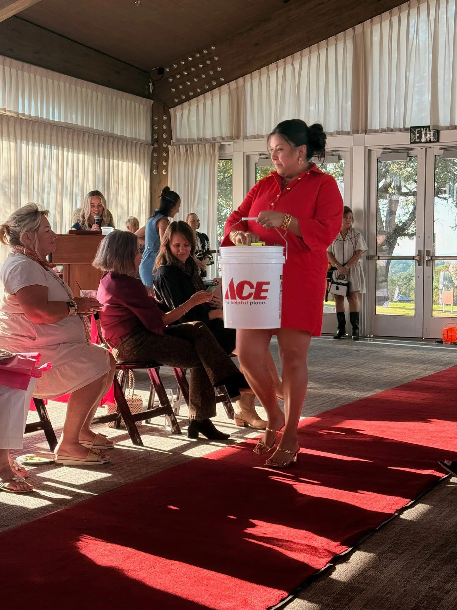 Woman in red dress carrying ACE bucket