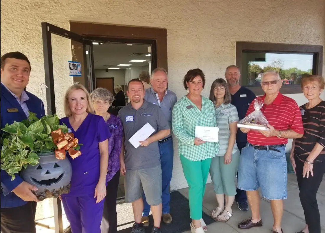 Group of people outside office holding gifts