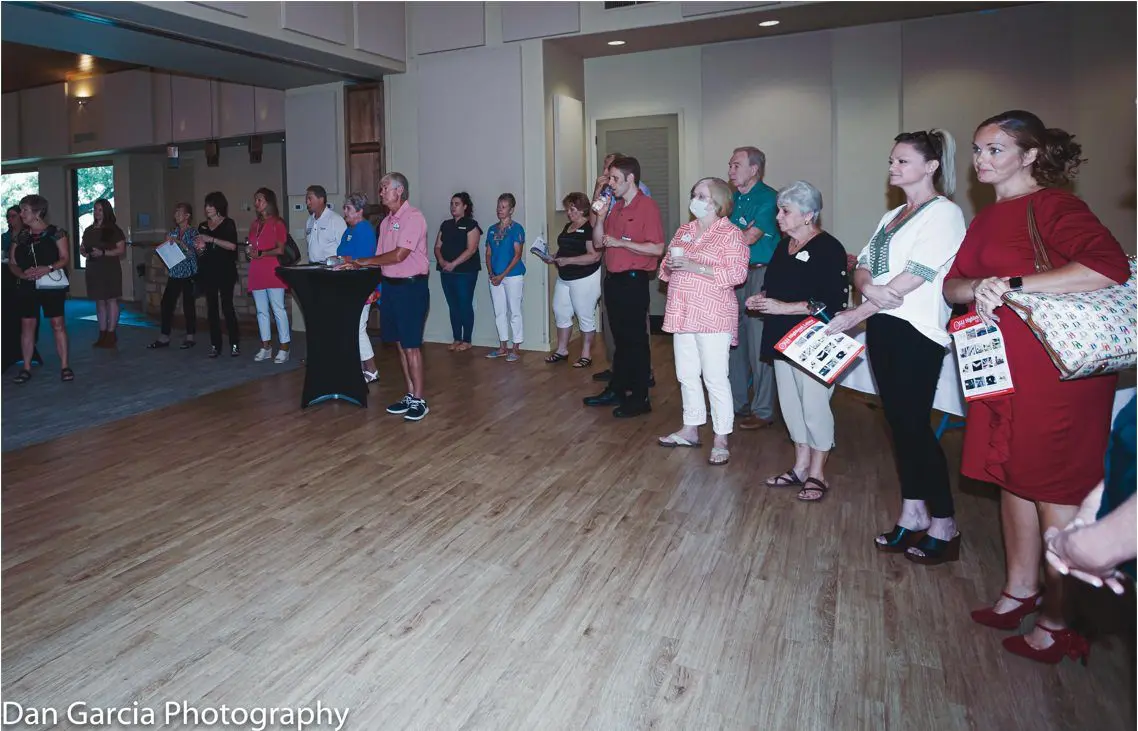 People standing in ballroom holding programs