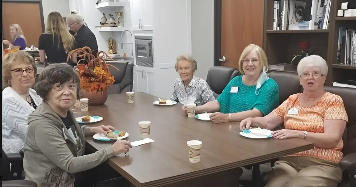 Group of older women sharing snacks around table
